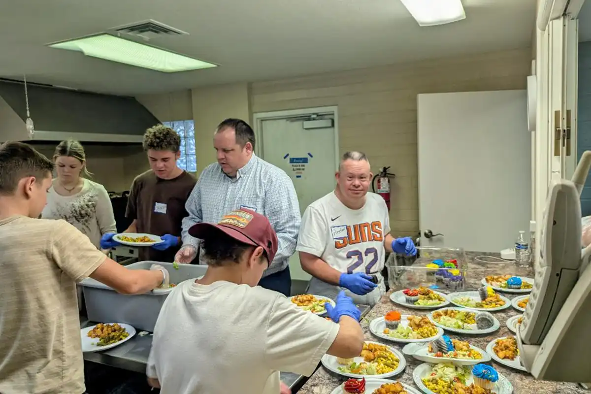Volunteers preparing and serving meals together during a La Mesa community outreach event