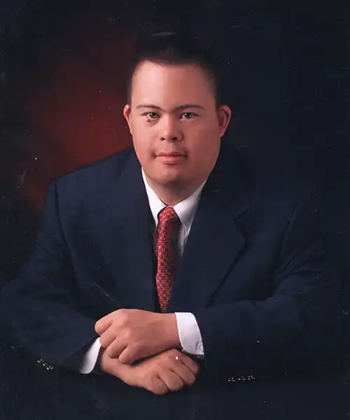 Portrait of Preston Hite wearing a suit and tie against a dark studio background